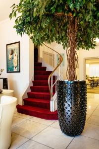 Ein Baum in einem Topf neben einer Treppe in der Unterkunft Hotel Prado in Ostende