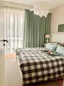 a bedroom with a large bed with a checkered blanket at Blue Sea Apartment in Międzyzdroje