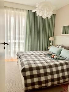 sypialnia z dużym łóżkiem z kocem szachowym w obiekcie Blue Sea Apartment w mieście Międzyzdroje