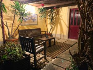 a patio with a bench and a table and a red door at Charming House Portas da Maia in Maia