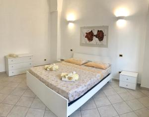 a bedroom with a large white bed in a room at Villetta Natalia in Torre Colimena