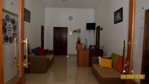 a living room with two couches and a tv at Centurion Resort in Habarana
