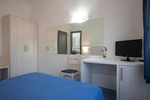 a hotel room with two beds and a television at Hotel La Playa in Cala Gonone