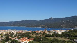 a town on a hill next to a body of water at Résidence Casa Régina in Propriano