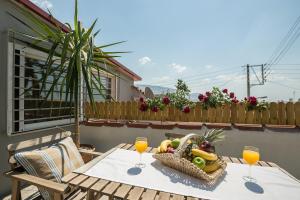 einen Tisch mit einem Obstkorb und zwei Gläsern Orangensaft in der Unterkunft Splendid Views from a Cozy Cottage with a Garden Terrace in Athen