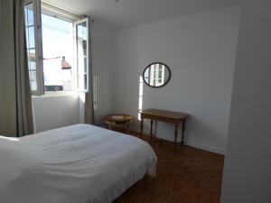 1 dormitorio con cama, mesa y ventana en Maison Basque en Biarritz