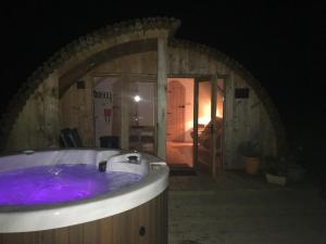 a bath tub with purple water in a room at Brynllwyd Glamping in Devils Bridge