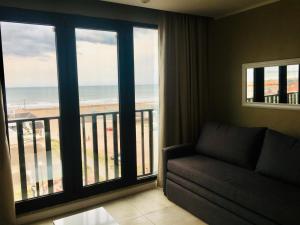 a living room with a couch and a view of the ocean at Michelle- Departamentos in Necochea