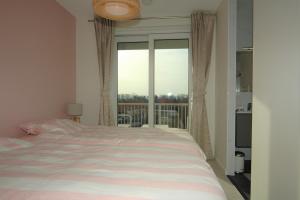a bedroom with a bed and a large window at La Promenade Le Normandy 54-201 in Cadzand