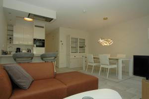 a living room with a couch and a table with chairs at La Promenade Le Normandy 54-201 in Cadzand