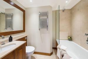 La salle de bains est pourvue d'une baignoire, de toilettes et d'un lavabo. dans l'établissement Grand Ambassadorial Duplex Apartment Hyde Park, à Londres