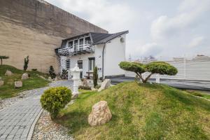 a small white house with a tree on a hill at Vila Sibiu in Sibiu