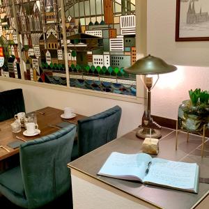 فندق دومسبيتزين في كولونيا: طاولة عليها مصباح وكتاب مفتوح عليها
