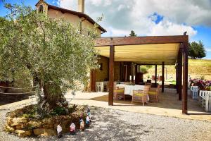 a house with a table and a tree in front of it at Borgo Monte Cedrone in Monte Santa Maria Tiberina