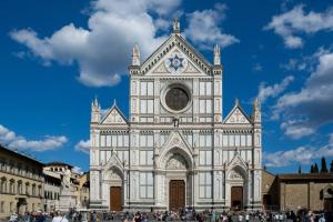 a large white building with a clock tower at Dante Experience Apartment in Florence