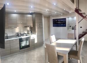 a kitchen with a white table and chairs and a sink at Villetta Natalia 2 in Torre Colimena