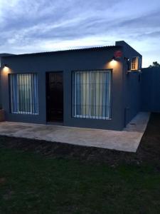 a blue house with a black door and a window at Hospedaje “ El Segoviano “ in Carmelo