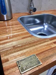 a metal sink with a sign on a wooden counter at Hospedaje “ El Segoviano “ in Carmelo +44 photos