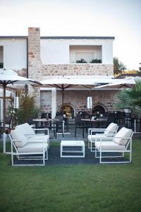 a group of white lounge chairs and umbrellas at Lanthia Resort in Santa Maria Navarrese