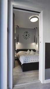 - une chambre dotée d'un lit avec une horloge murale dans l'établissement Apartament Baltica z ogródkiem - w ustronnym miejscu tuż przy plaży, à Rogowo