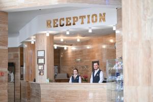 two people standing in the front of a restaurant at URAL TAU Hotel in Ufa