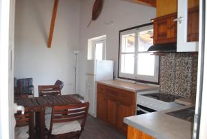 a kitchen with a white refrigerator and a table with chairs at Beaufort apartment in Stoupa