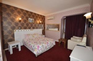 a hotel room with a bed and a chair at Antik Otel in Ankara