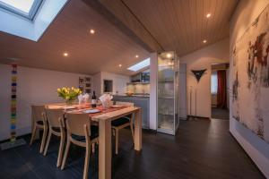 a dining room with a table and chairs and a kitchen at Chalet Primula Penthouse in Wengen