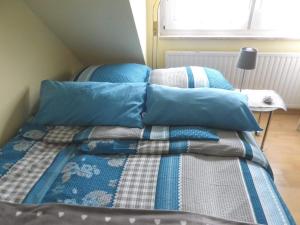 a bed with blue pillows on it in a room at Ferienzimmer Bella Casa in Biebesheim