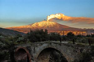 a volcano with a bridge in front of a mountain at Good Morning Etna in Bronte