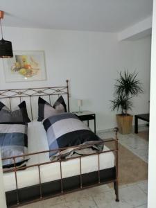 una camera da letto con un letto con cuscini bianchi e neri di Hinterländer Schweiz a Gladenbach