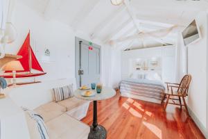 a living room with a table and a bed at Casa da Praia in Câmara de Lobos