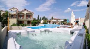 a pool with a hot tub next to a house at Imerti Resort Hotel in Skala Kallonis