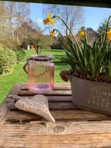 a vase and a plant on a wooden table at Villa Topas in Wilhelmshaven