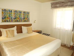 um quarto com uma cama e uma pintura na parede em Hotel Mar Azul em Lagos