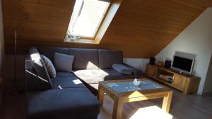 ein Wohnzimmer mit einem Sofa und einem Tisch in der Unterkunft Ferienwohnung Dresden Nickern in Dresden