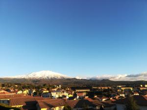 a city with a snow covered mountain in the background at Good Morning Etna in Bronte