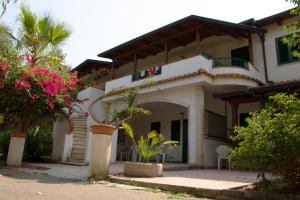 a white house with a balcony and flowers at Baia di Zambrone in Zambrone