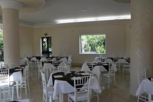 a banquet hall with white tables and white chairs at Baia di Zambrone in Zambrone