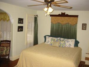 a bedroom with a bed with a ceiling fan at Thomas Webster House in Cape May