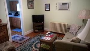 un soggiorno con un divano e una TV di Thomas Webster House a Cape May