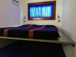 a bed sitting on a shelf in a room with a window at Rosa dei Venti in Procchio