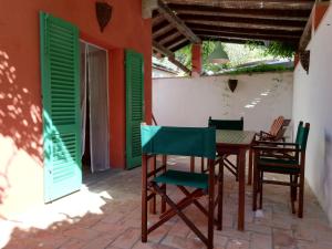 a table and chairs on a patio with green shutters at Rosa dei Venti in Procchio