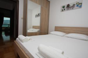 a bedroom with a white bed and a mirror at The Old Town Terrace Apartments in Budva
