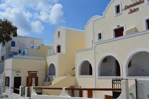 una fila de edificios con un cielo azul en el fondo en Anemomilos Suites, en Fira