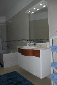 a bathroom with a sink and a large mirror at Ericeira Sunset Apartment in Ericeira +37 photos