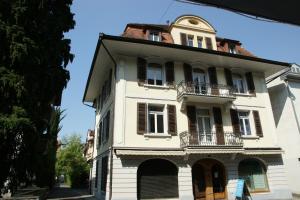 インターラーケンにあるスイス ホリデーズ アパートメント ローゼンシュトラッセ 10の古い白い家(バルコニー付)
