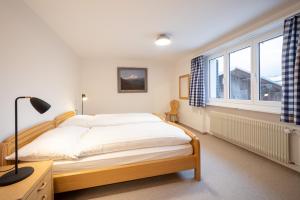 a bedroom with a bed and a large window at Casa Casura in Falera