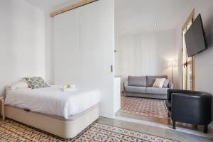 バルセロナにあるFlateli Rosselloのベッドルーム(ベッド1台、ソファ付)