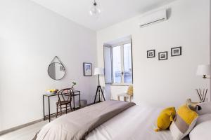 biała sypialnia z dużym łóżkiem i oknem w obiekcie Manuela Apartments Centro storico w mieście Napoli